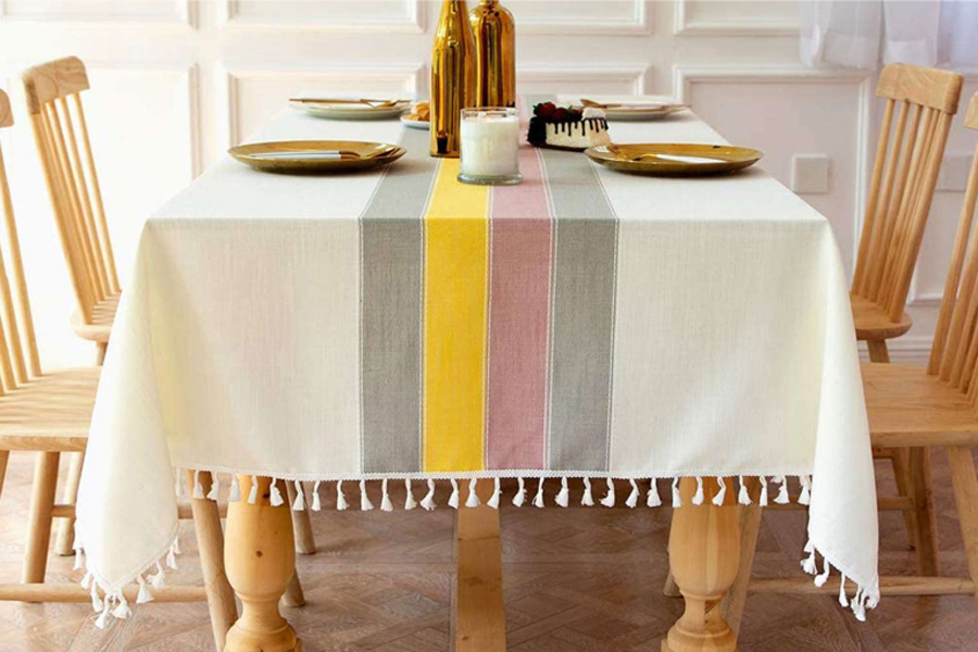 Dining table set with linen table cloth and yellow plates.